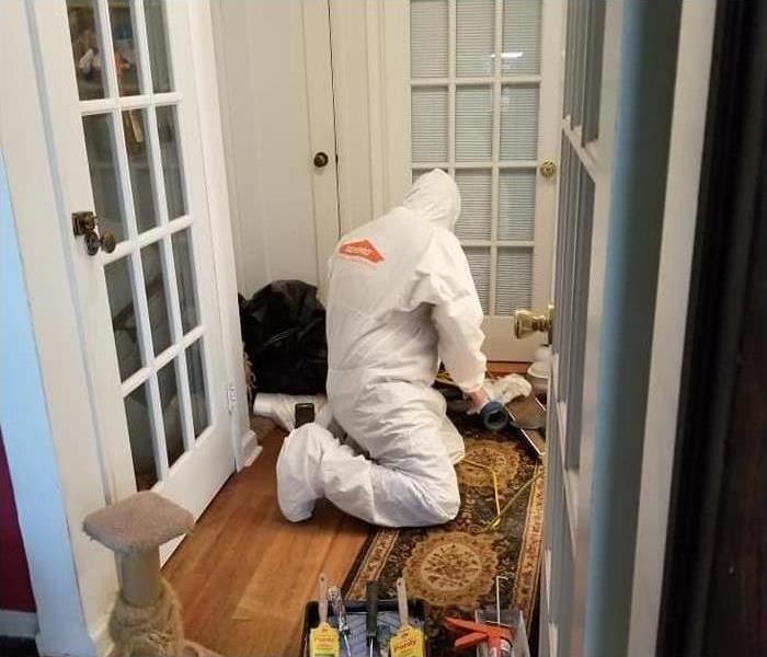 SERVPRO employee cleaning a home after water damage
