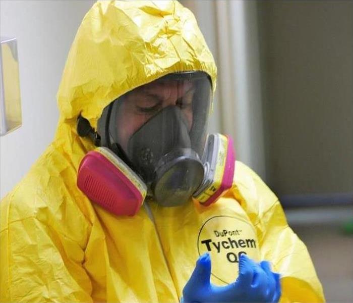 man with a yellow protective suit, gloves and face mask on